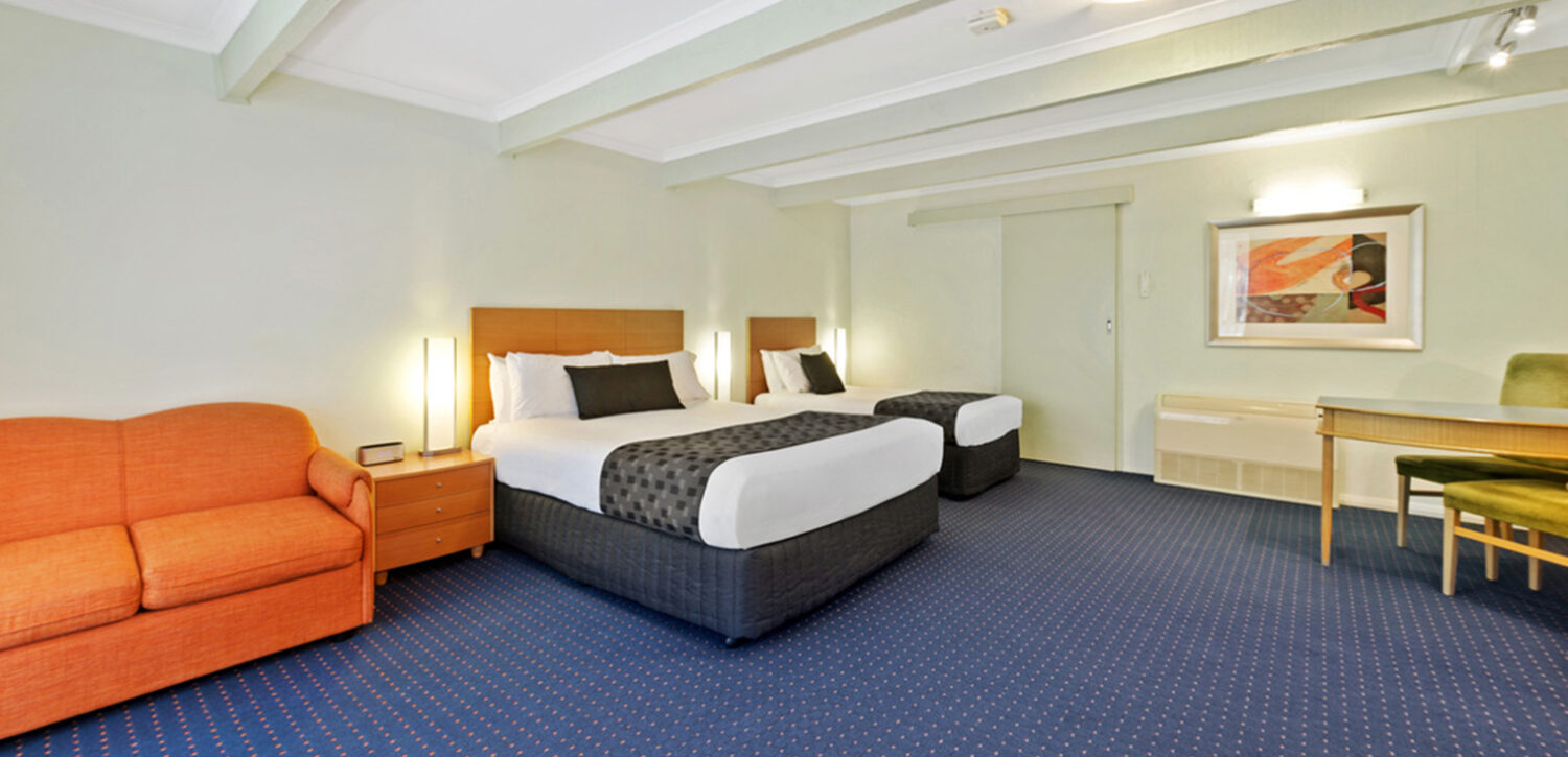 albury-resort-accommodation-queen-suite-bed-lounge | Quality Resort Siesta